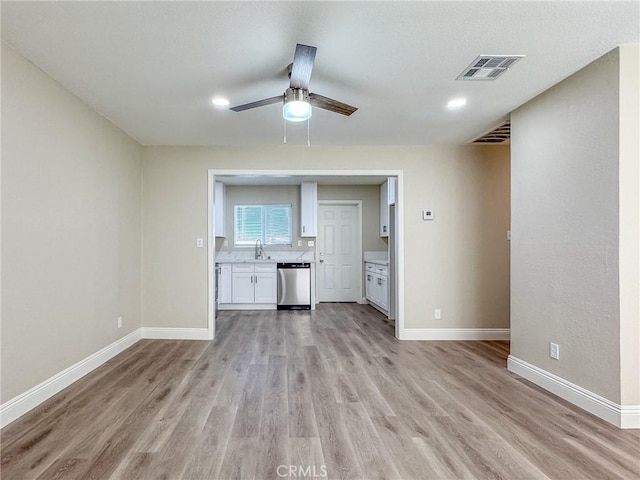 unfurnished living room featuring ceiling fan, sink, and light hardwood / wood-style flooring