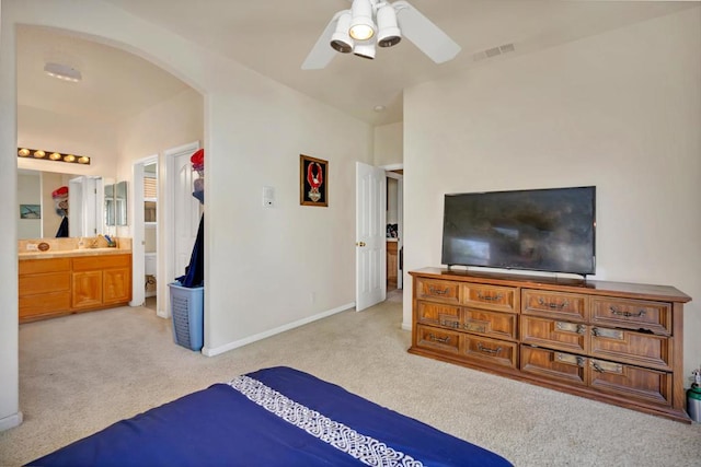 carpeted bedroom featuring ceiling fan and ensuite bathroom