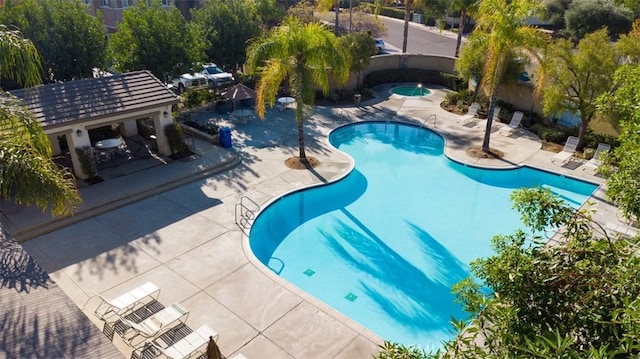 view of pool with a patio and a hot tub