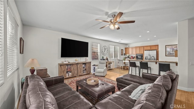 living room with ceiling fan and light hardwood / wood-style floors