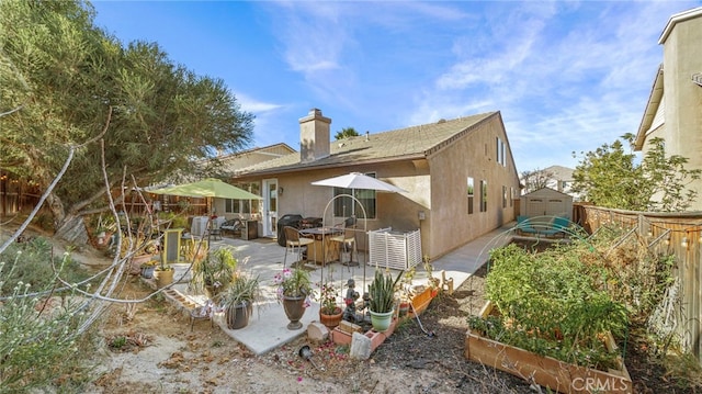 rear view of property featuring a storage shed and a patio