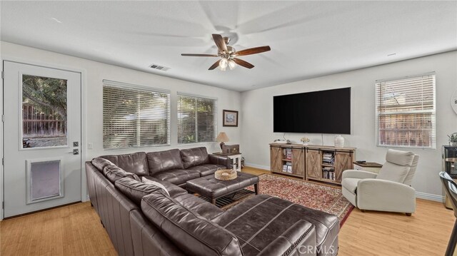 living room featuring ceiling fan and light hardwood / wood-style flooring