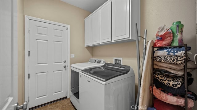 clothes washing area featuring washing machine and clothes dryer and cabinets