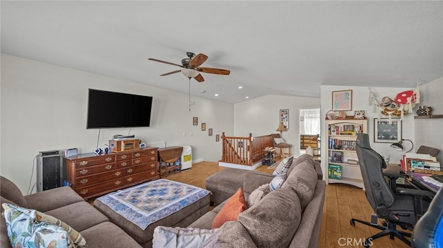 living room featuring hardwood / wood-style flooring, ceiling fan, and vaulted ceiling