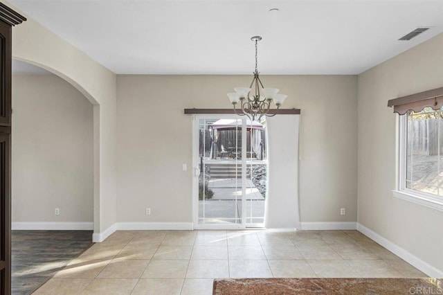 unfurnished dining area featuring a notable chandelier and light tile patterned floors