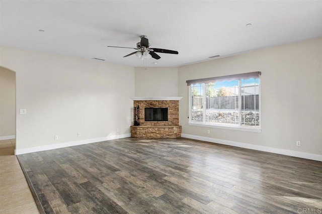 unfurnished living room featuring hardwood / wood-style flooring, ceiling fan, and a fireplace