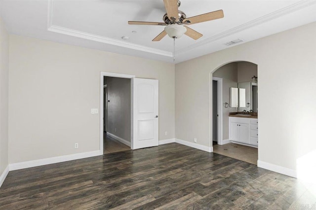 unfurnished room featuring ornamental molding, a raised ceiling, ceiling fan, and dark wood-type flooring