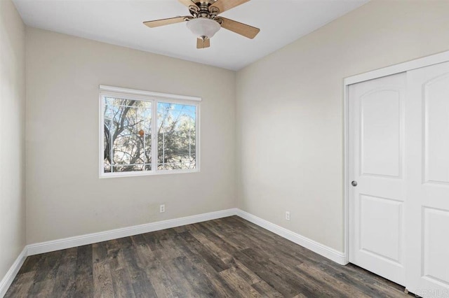 spare room featuring ceiling fan and dark wood-type flooring