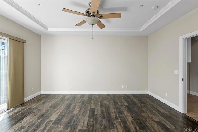 spare room with dark hardwood / wood-style floors, a tray ceiling, and crown molding