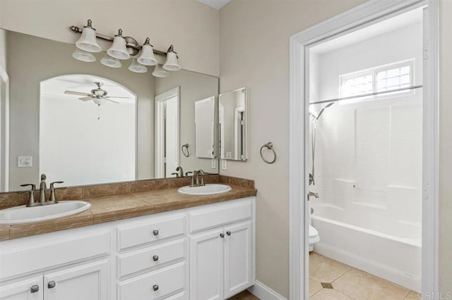 full bathroom with shower / bath combination, vanity, ceiling fan, tile patterned flooring, and toilet