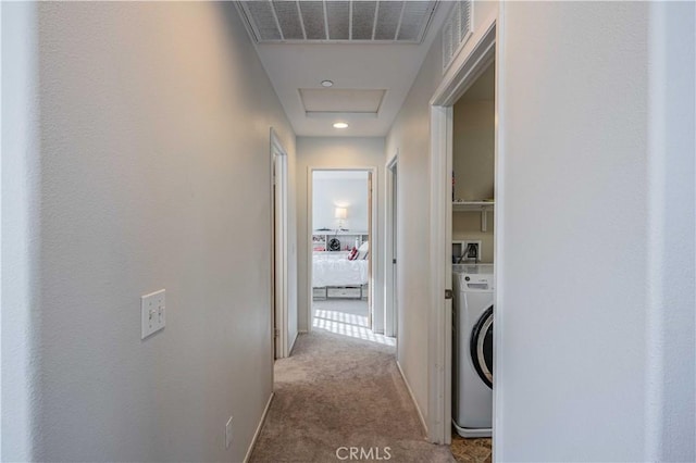 hall featuring light carpet and washer / clothes dryer