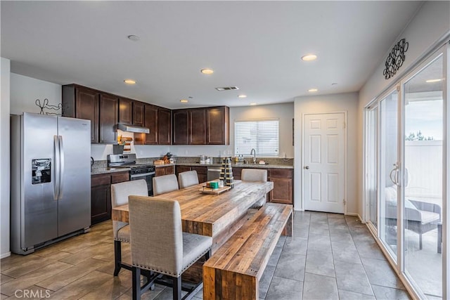 kitchen featuring appliances with stainless steel finishes, a kitchen island, sink, and dark brown cabinets