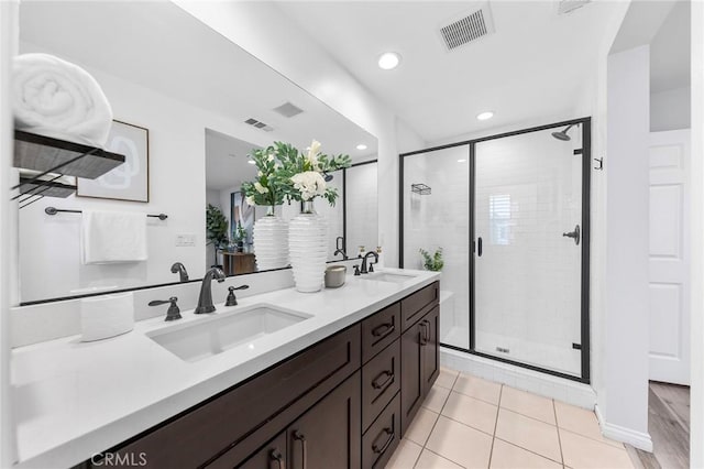 bathroom with tile patterned flooring, vanity, and an enclosed shower