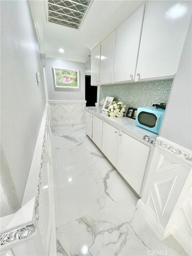 kitchen with white cabinets and washer / clothes dryer