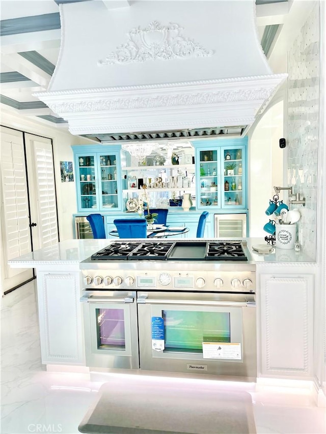 kitchen with white cabinets, custom range hood, and range with two ovens