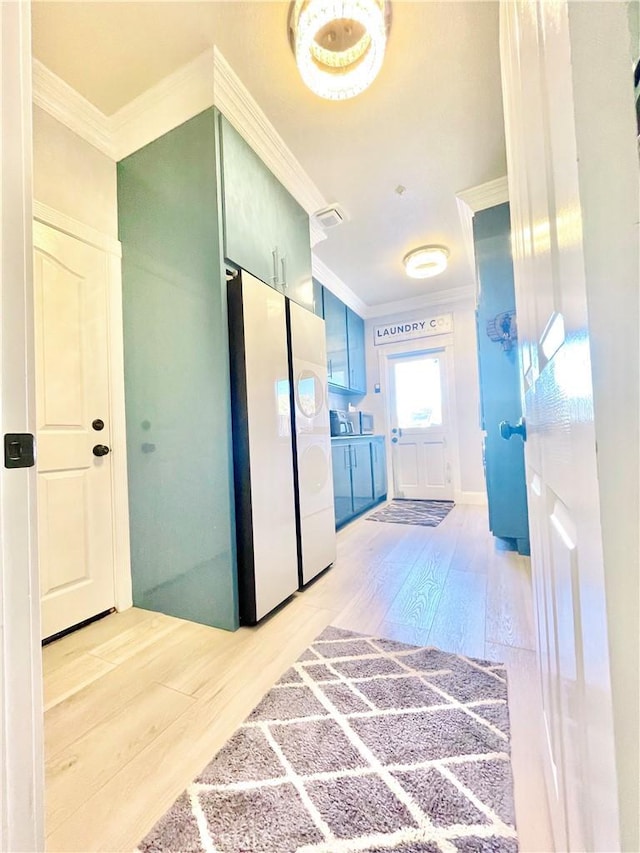 corridor with light wood-type flooring and crown molding