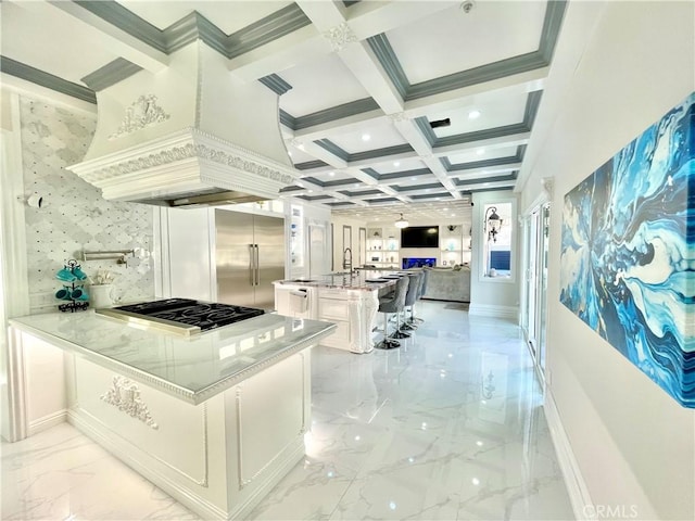 kitchen with white cabinetry, gas cooktop, kitchen peninsula, a breakfast bar area, and custom range hood