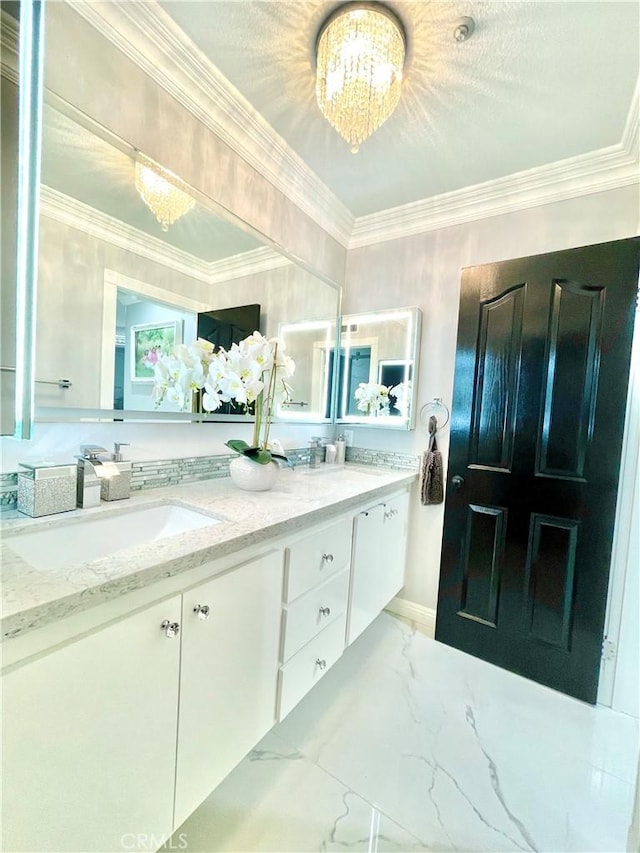 bathroom featuring vanity, an inviting chandelier, and crown molding