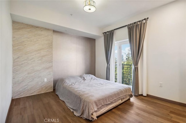 bedroom featuring access to exterior and wood-type flooring