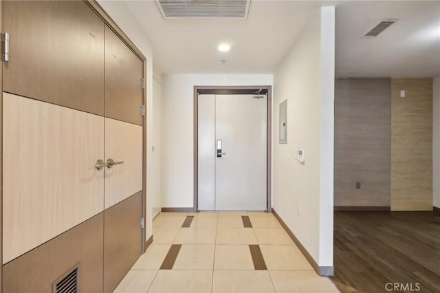 hall with elevator and light hardwood / wood-style flooring