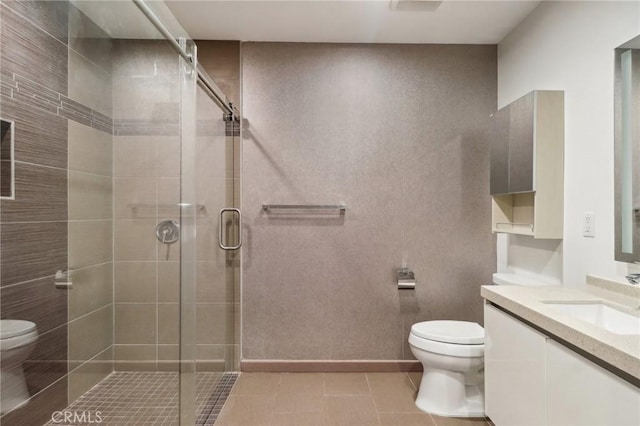 bathroom featuring tile patterned floors, a shower with door, vanity, and toilet