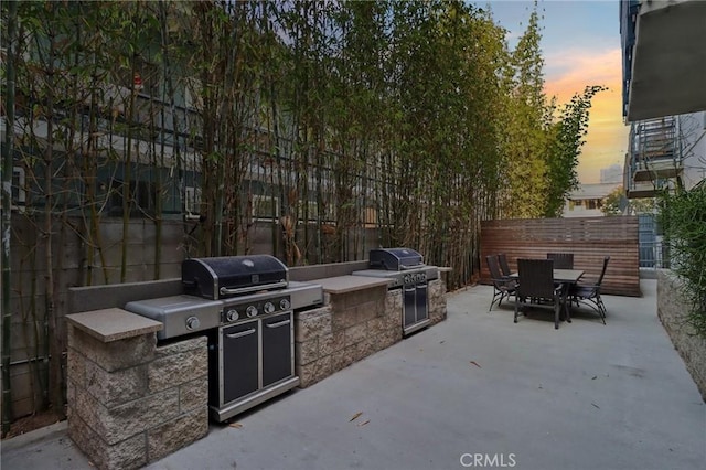 view of patio with an outdoor kitchen and a grill