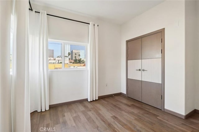 unfurnished bedroom featuring a closet and light hardwood / wood-style flooring