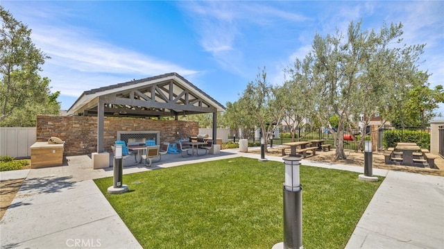 view of property's community featuring a gazebo, a patio area, outdoor lounge area, and a yard