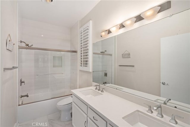 full bathroom featuring vanity, bath / shower combo with glass door, and toilet