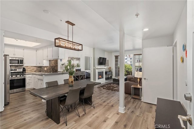 dining area with sink and light wood-type flooring