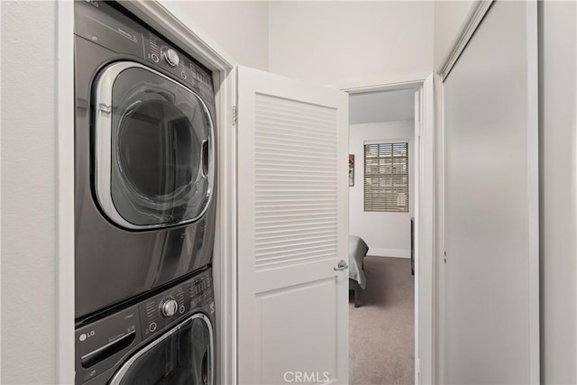 clothes washing area featuring carpet flooring and stacked washer and dryer