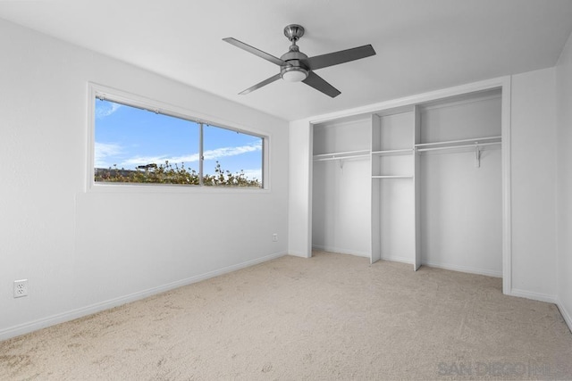 unfurnished bedroom featuring ceiling fan, a closet, and light colored carpet