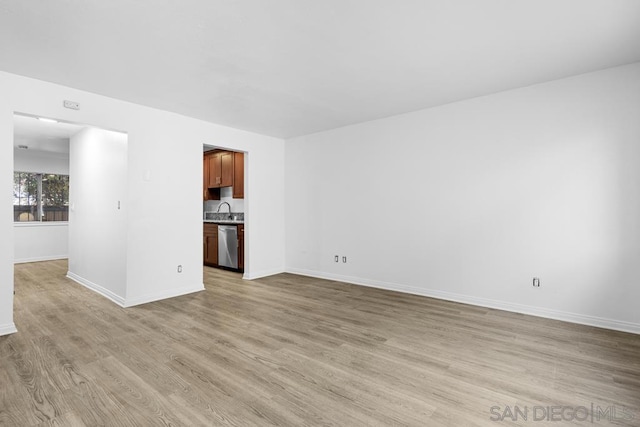 unfurnished living room featuring light wood-type flooring and sink