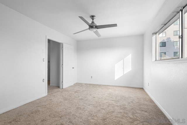 carpeted spare room with ceiling fan