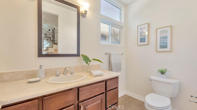 bathroom with vanity, toilet, and wood-type flooring