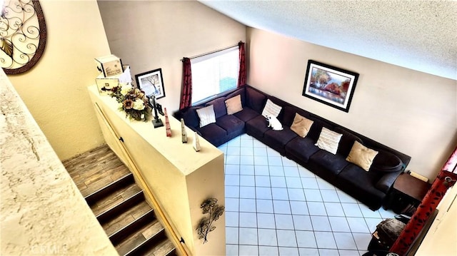 living room with tile patterned flooring, a textured ceiling, and lofted ceiling