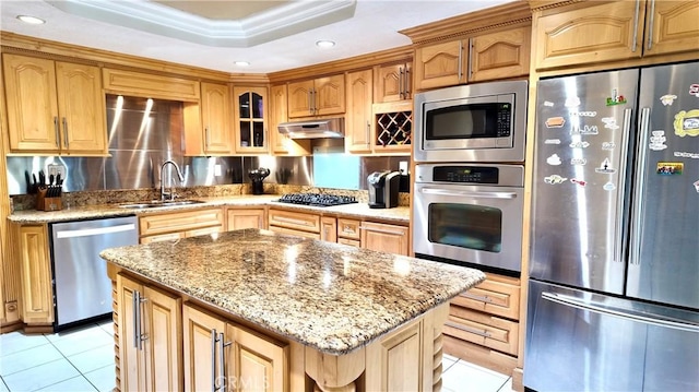 kitchen featuring a center island, sink, appliances with stainless steel finishes, light tile patterned floors, and ornamental molding