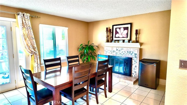 tiled dining room featuring a tile fireplace and a textured ceiling