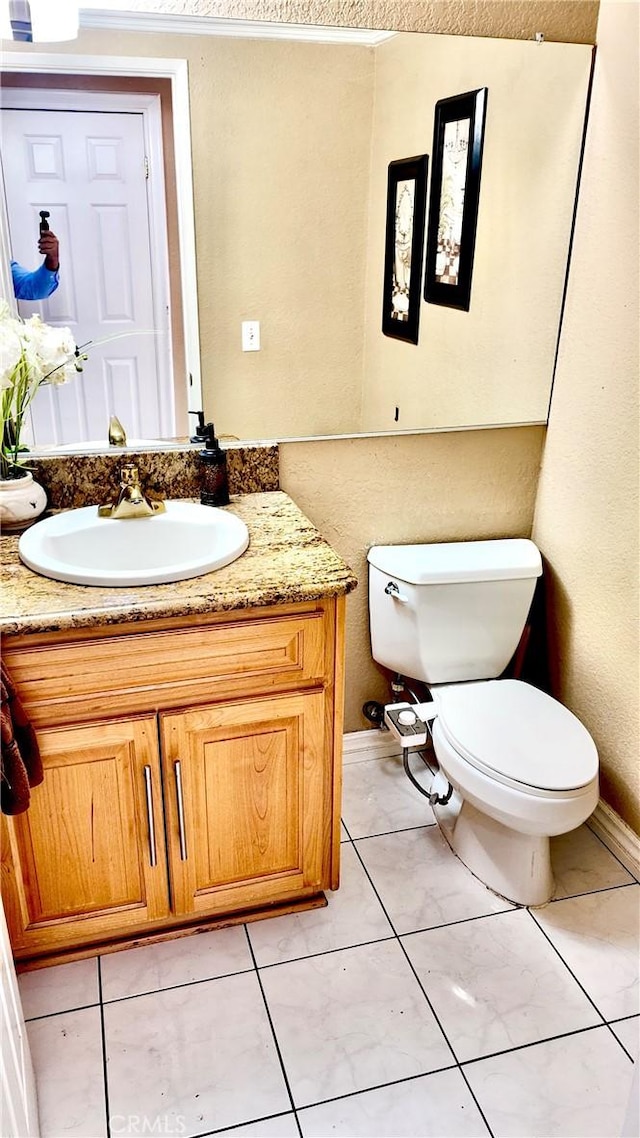 bathroom with tile patterned flooring, vanity, and toilet