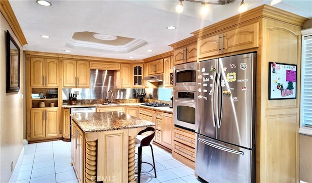 kitchen with a center island, sink, light tile patterned floors, a kitchen bar, and stainless steel appliances