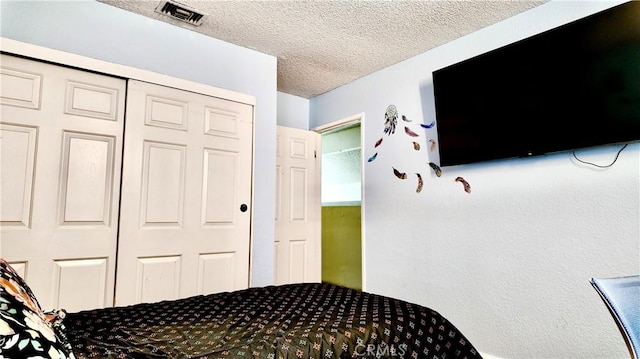 bedroom with a textured ceiling and a closet