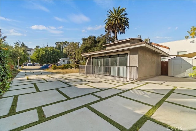 back of property featuring a patio and a shed