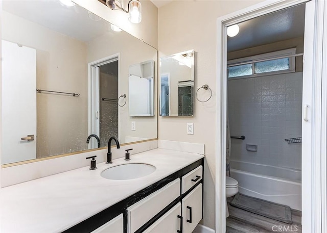 full bathroom with hardwood / wood-style floors, vanity, toilet, and shower / bathtub combination