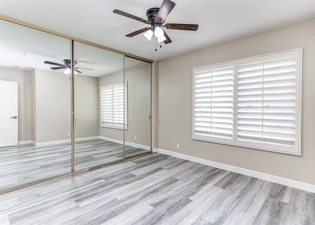 unfurnished bedroom with ceiling fan, a closet, and light hardwood / wood-style flooring