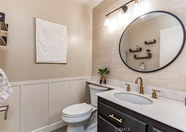 bathroom featuring backsplash, vanity, tile walls, and toilet