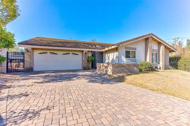 ranch-style home featuring a garage and a front lawn