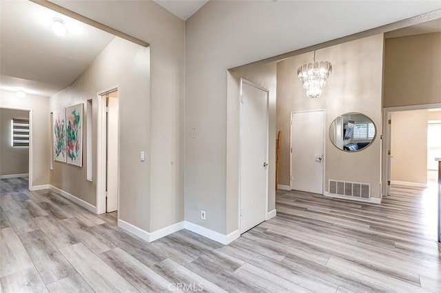 foyer featuring light wood-type flooring and an inviting chandelier