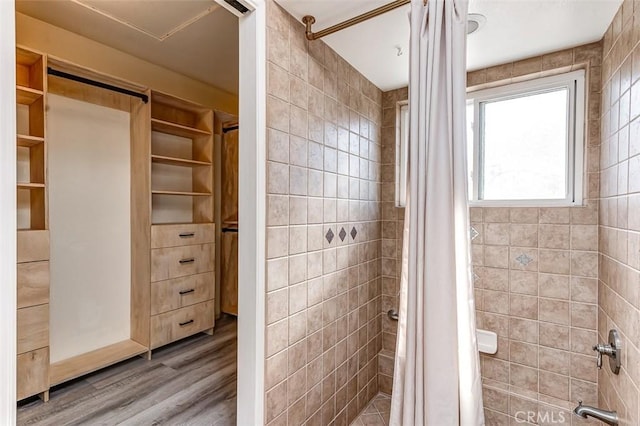 bathroom featuring wood-type flooring and tile walls