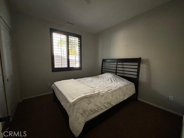 bedroom featuring a closet and dark carpet