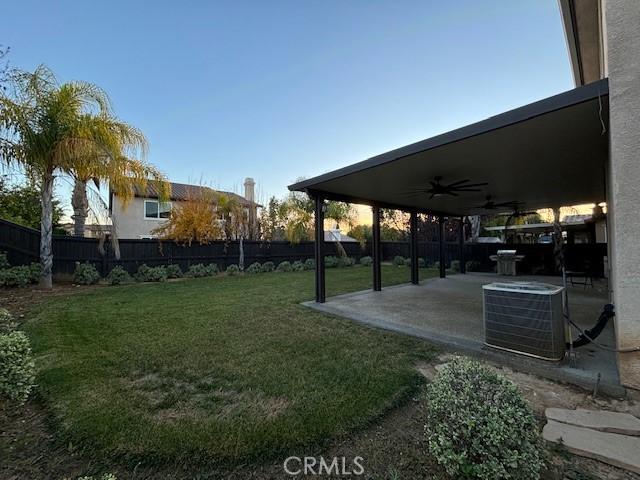 view of yard featuring central air condition unit, a patio area, and ceiling fan